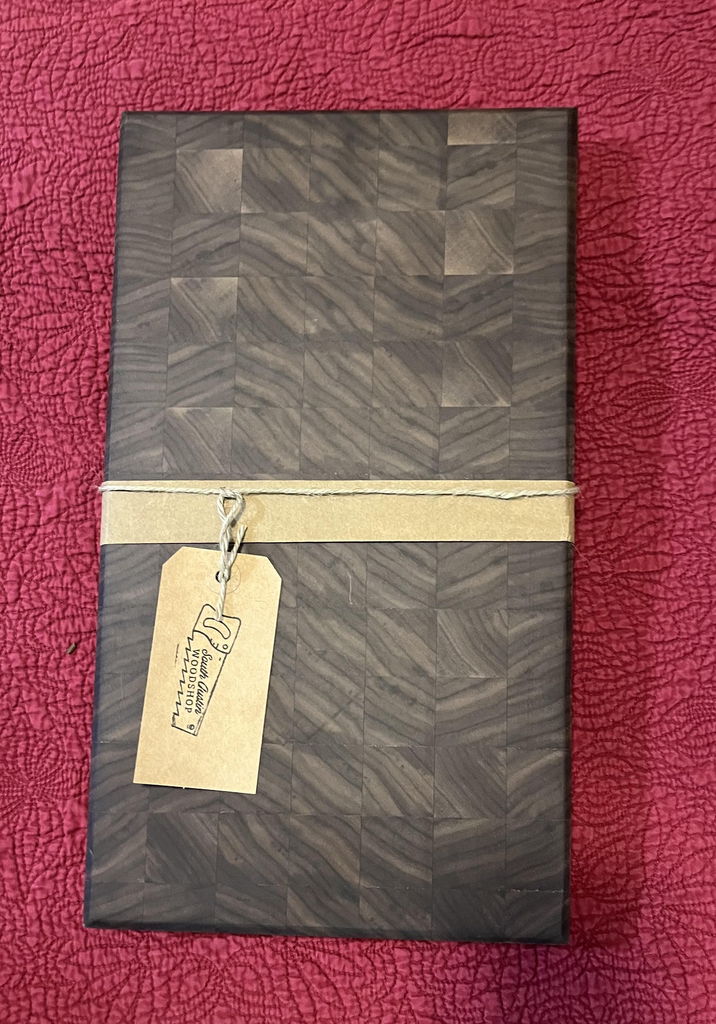End-grain walnut cutting board with shop tag