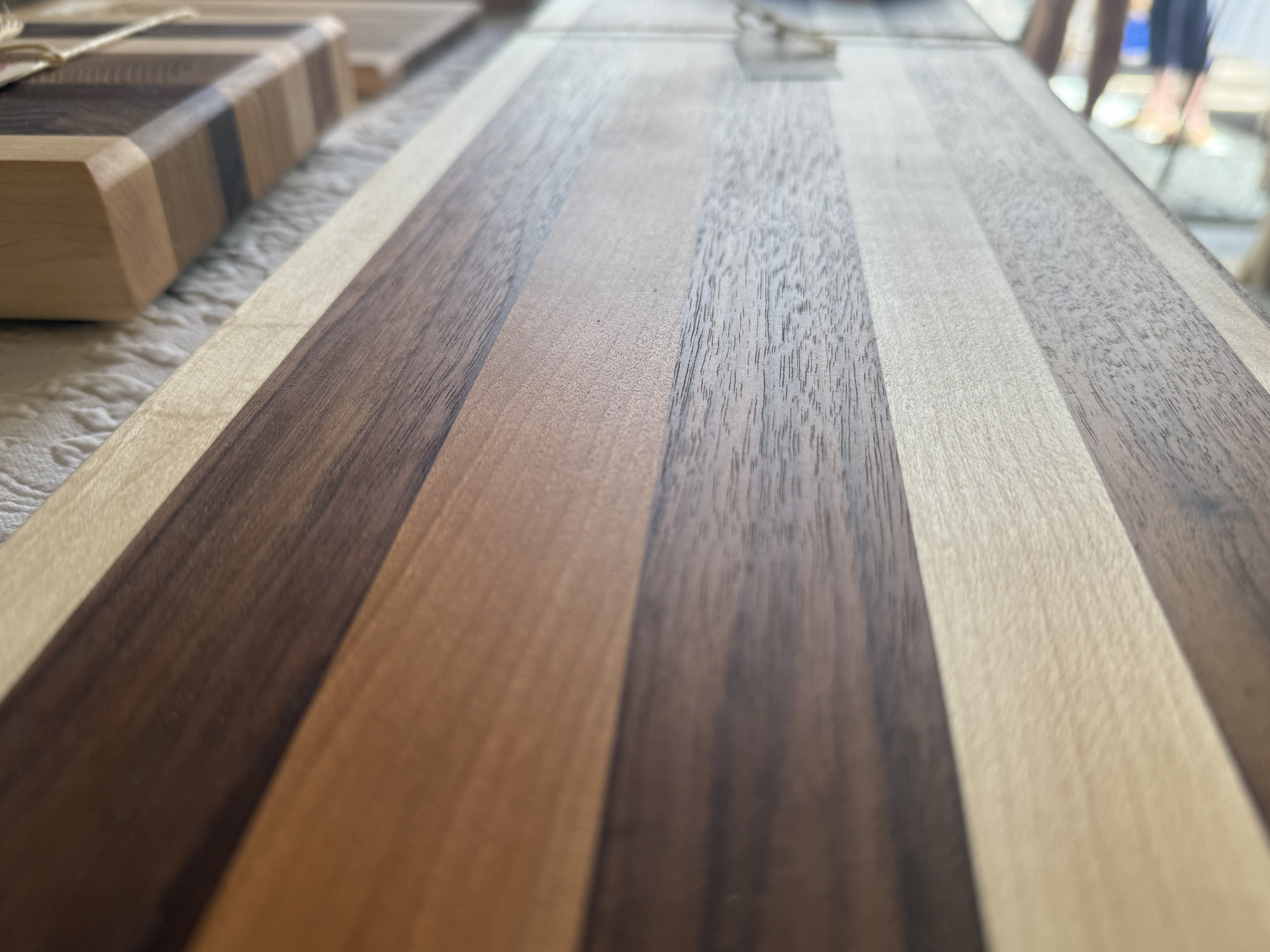 Low-angle view of striped walnut and maple cutting board surface