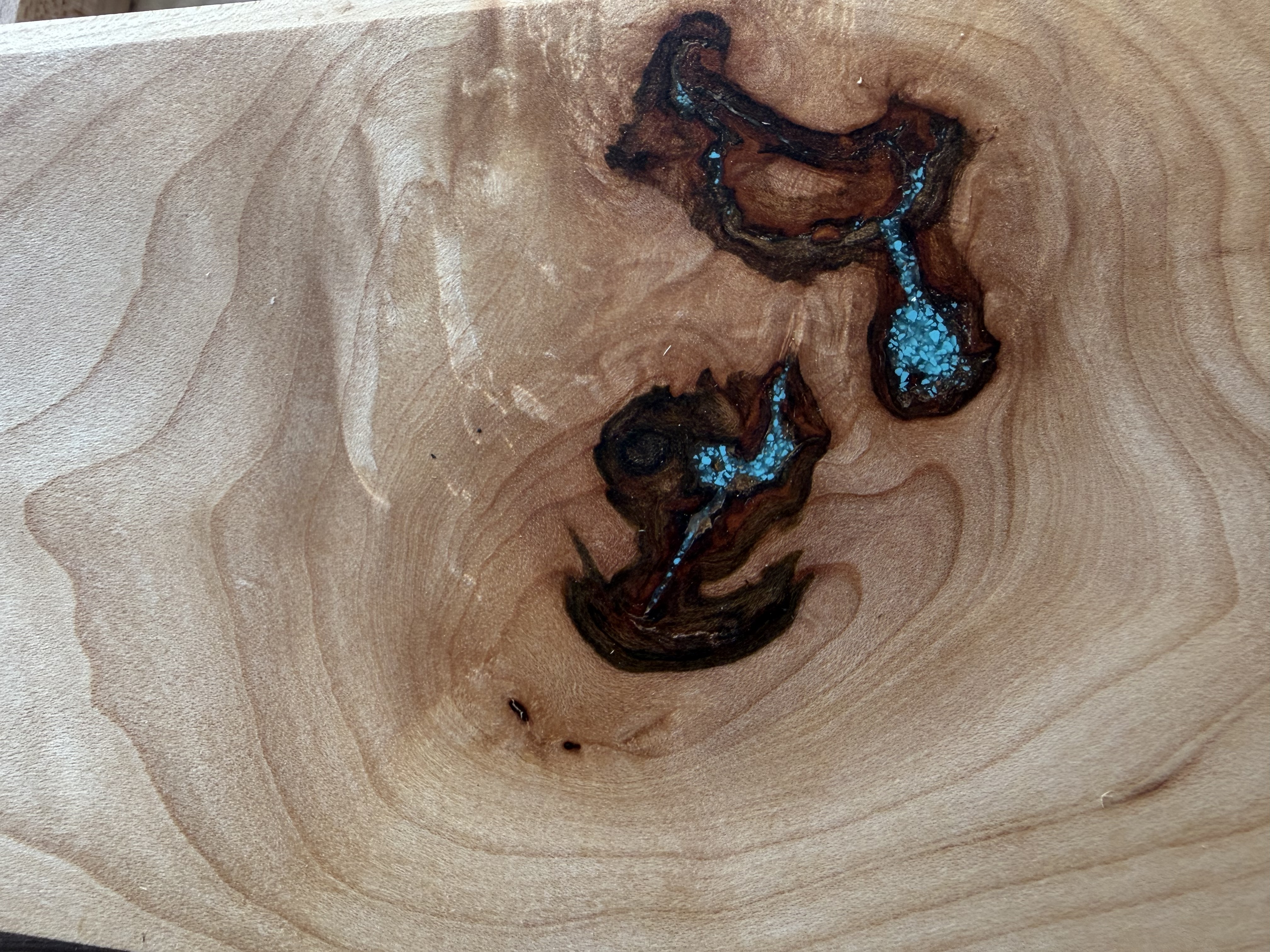 Close-up of turquoise epoxy inlay in maple board
