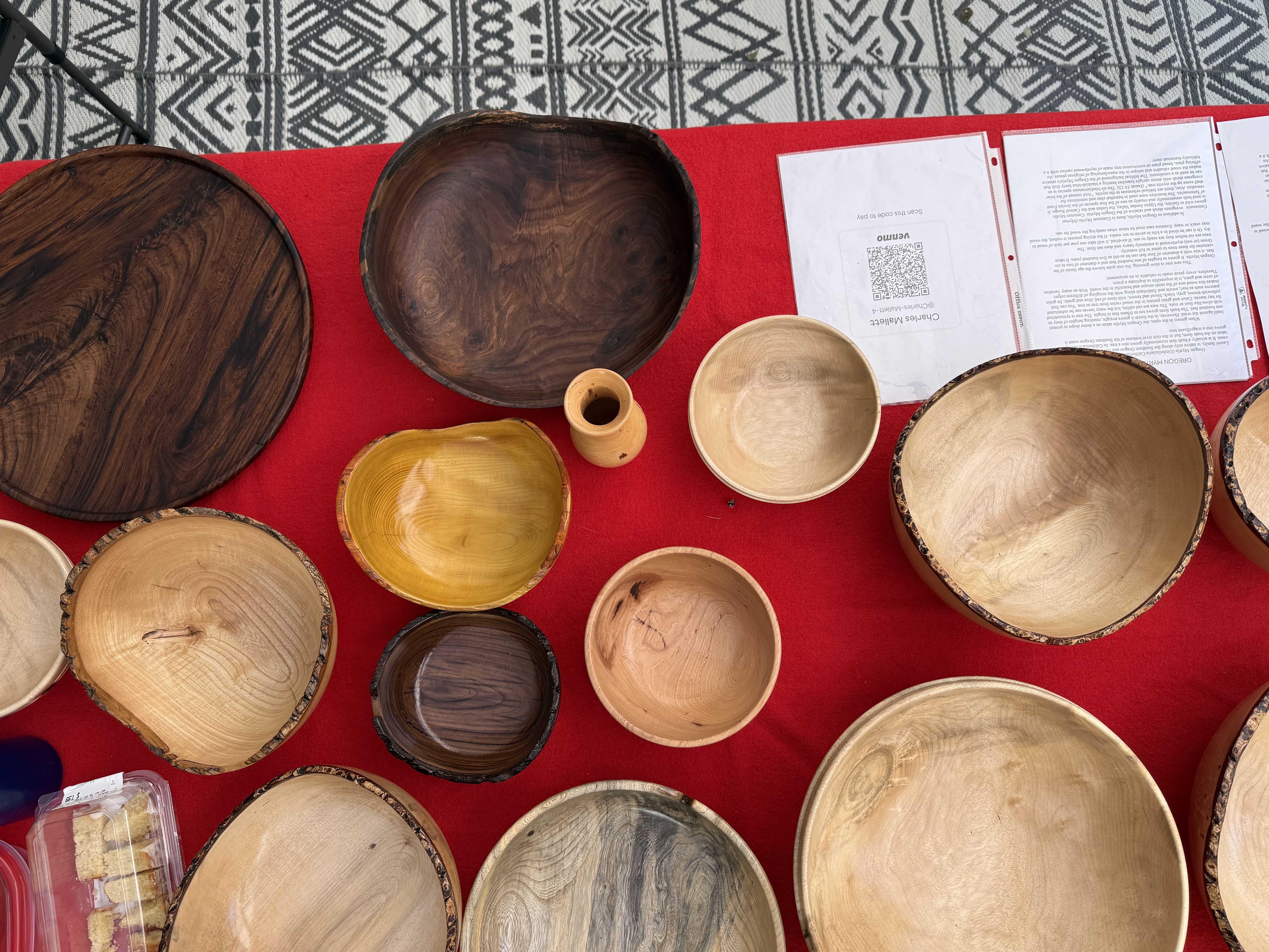 Overhead view of turned wood bowls, vessels, and a vase on red felt